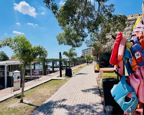A bunch of life jackets are hanging on a brick walkway