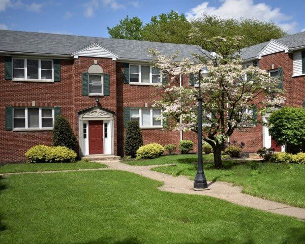 A brick apartment building with a tree in front of it