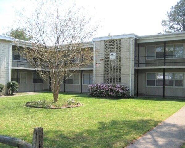 A large apartment building with a tree in front of it