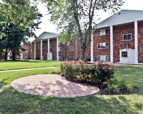 A large apartment building with a brick walkway in front of it