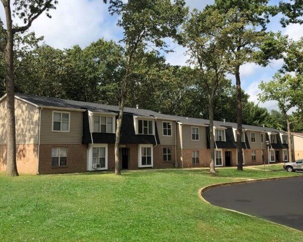A row of apartment buildings with trees in the background