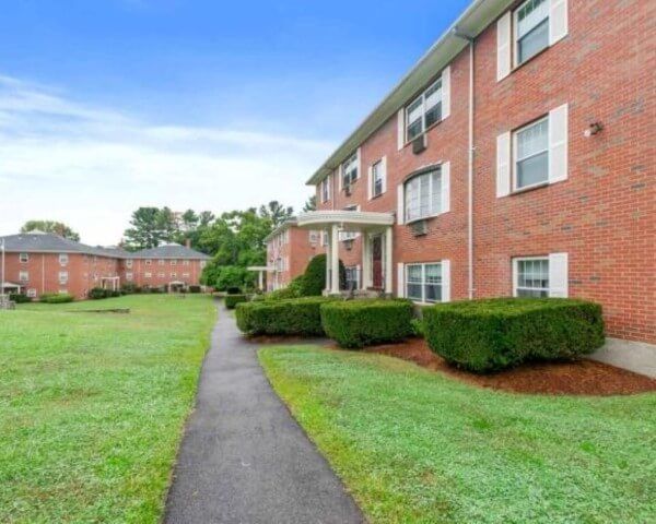 A brick apartment building with a walkway leading to it