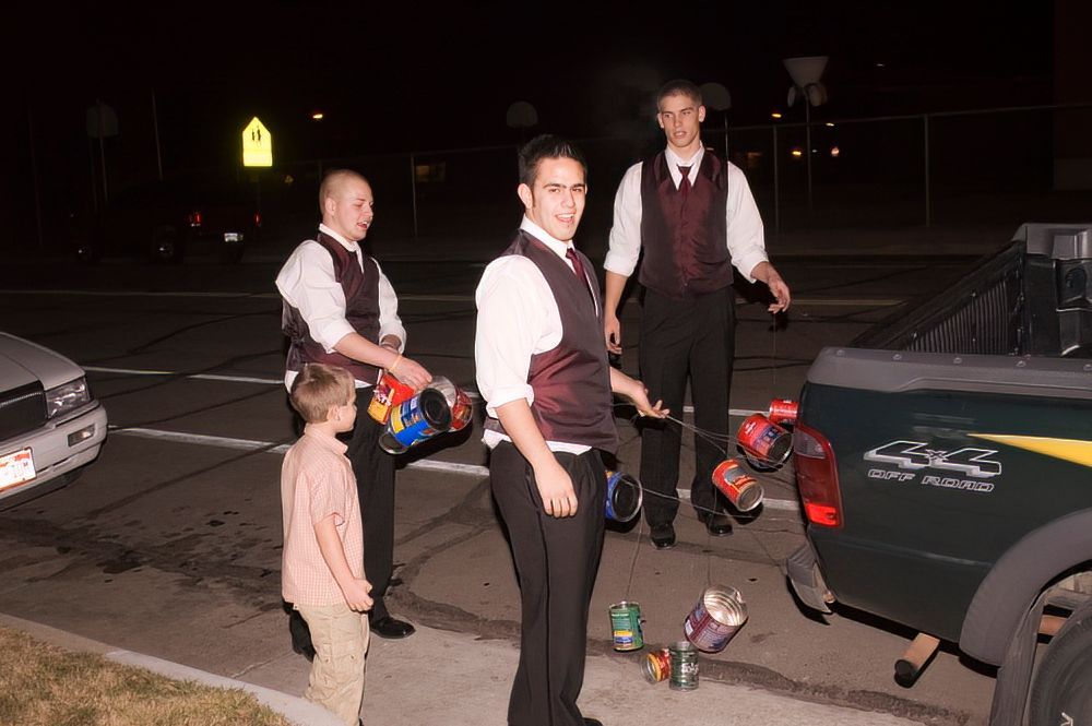 A group of men are standing in front of a green truck.