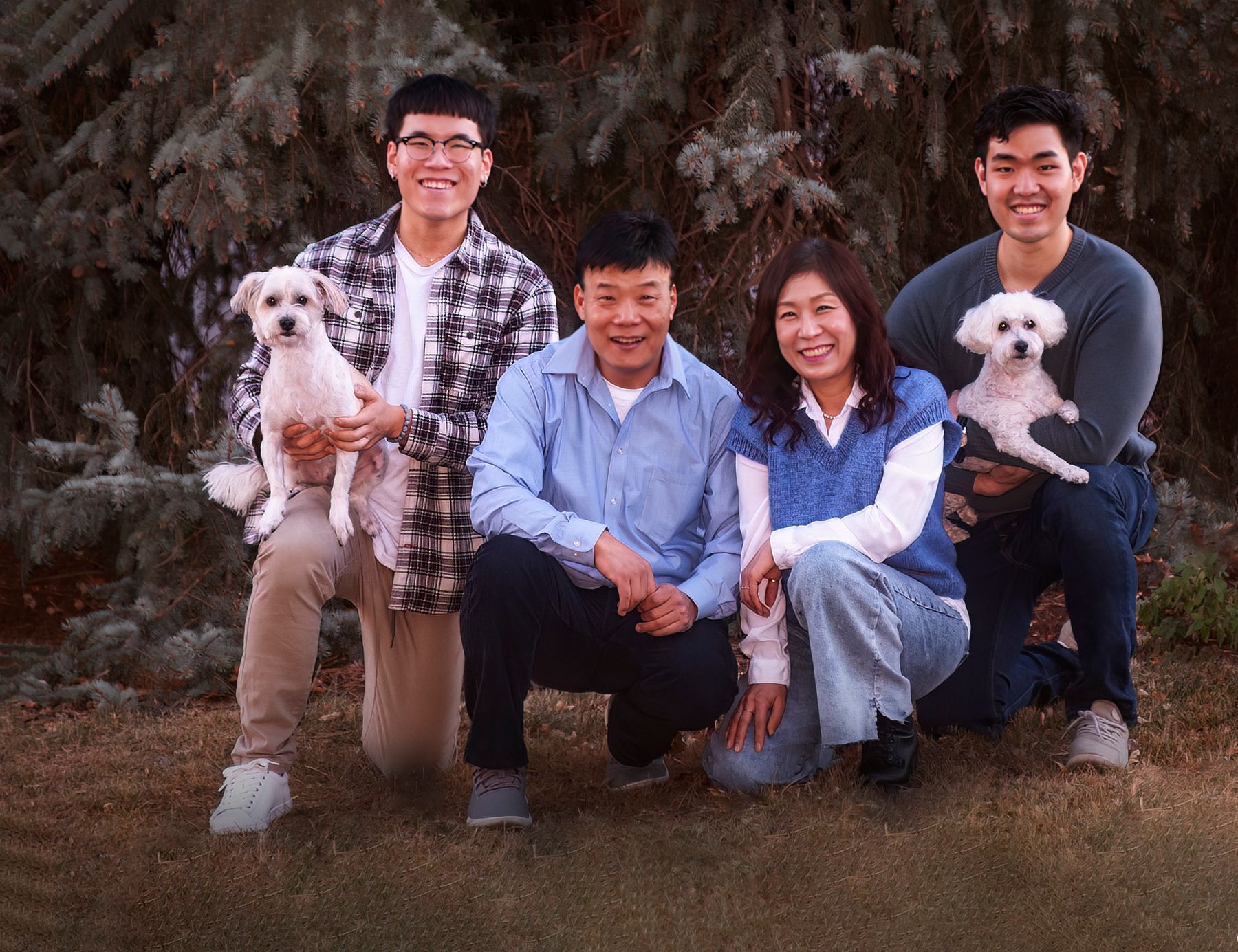 A family posing for a picture with two dogs