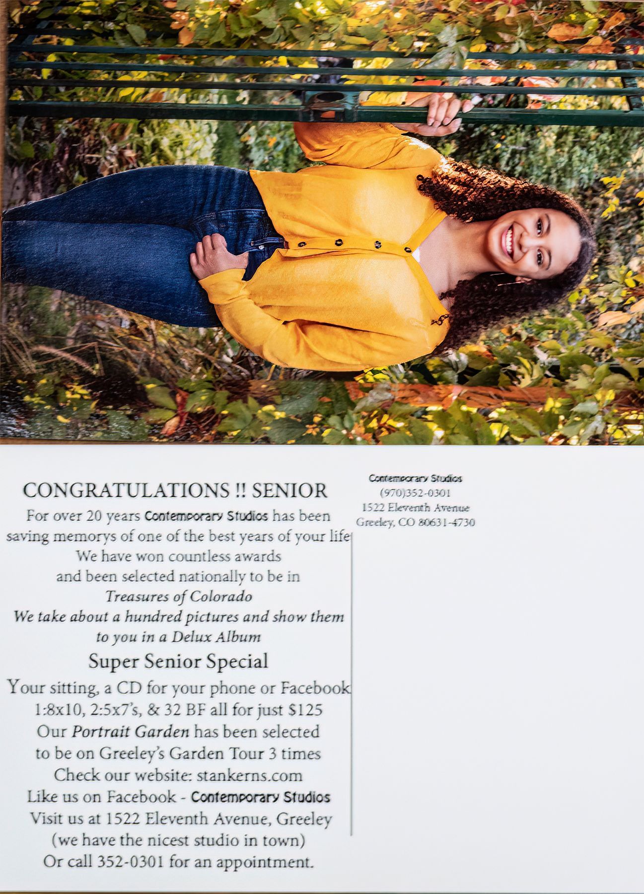 A woman in a yellow sweater and blue jeans is laying on a bench.
