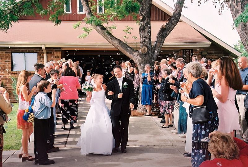 A bride and groom are walking down the aisle at their wedding