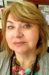 A close up of a woman wearing a necklace and earrings.