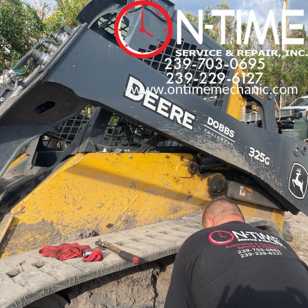 A man is working on a deere skid steer