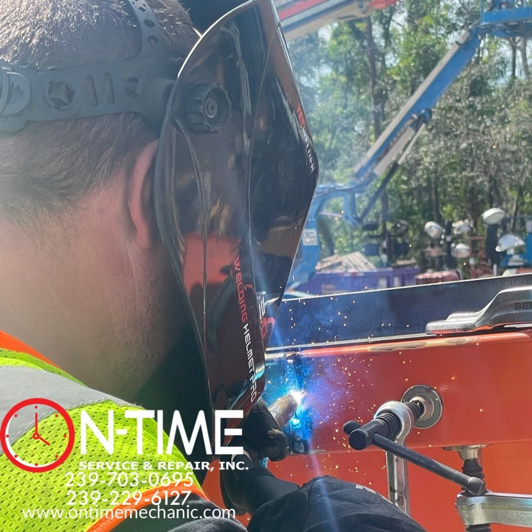 A man wearing a welding mask is welding a piece of metal