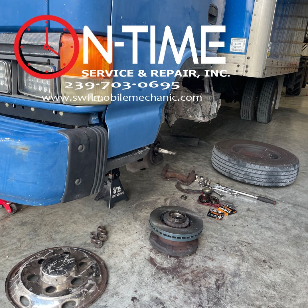 A blue truck is being serviced by on-time service and repair inc.