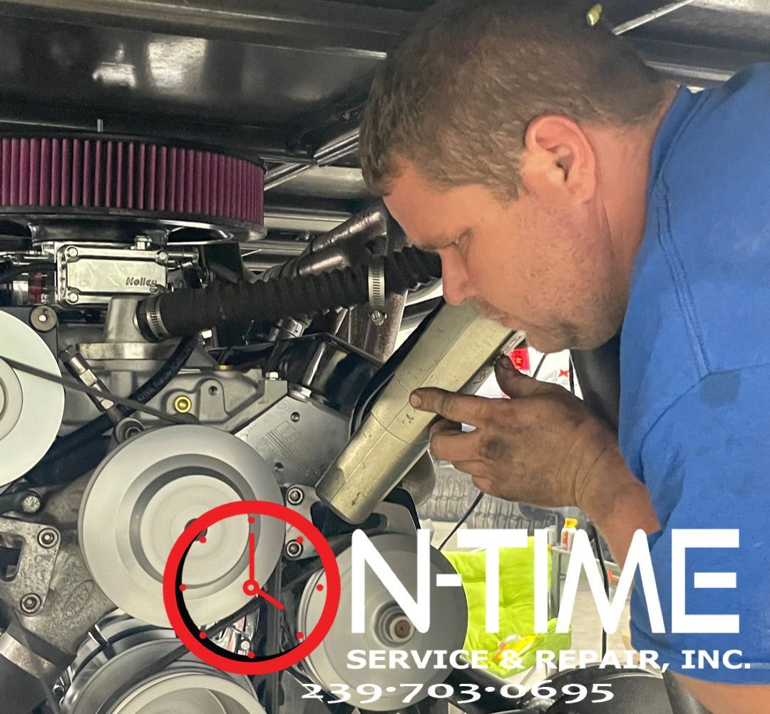 A man in a blue shirt is working on a car engine