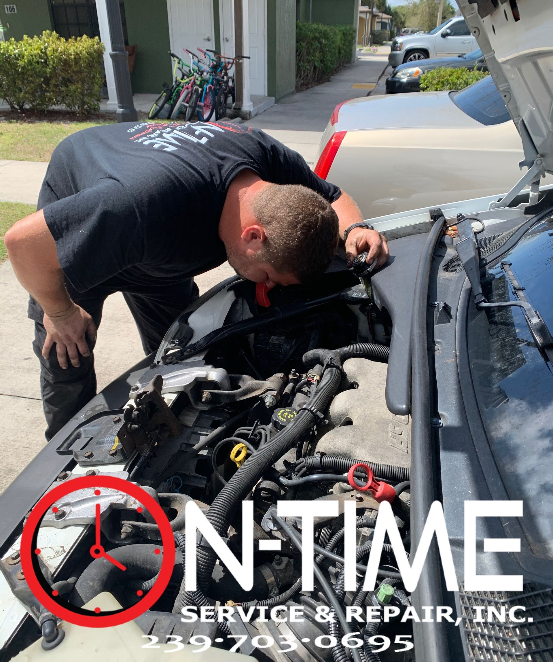 A man is looking under the hood of a car.
