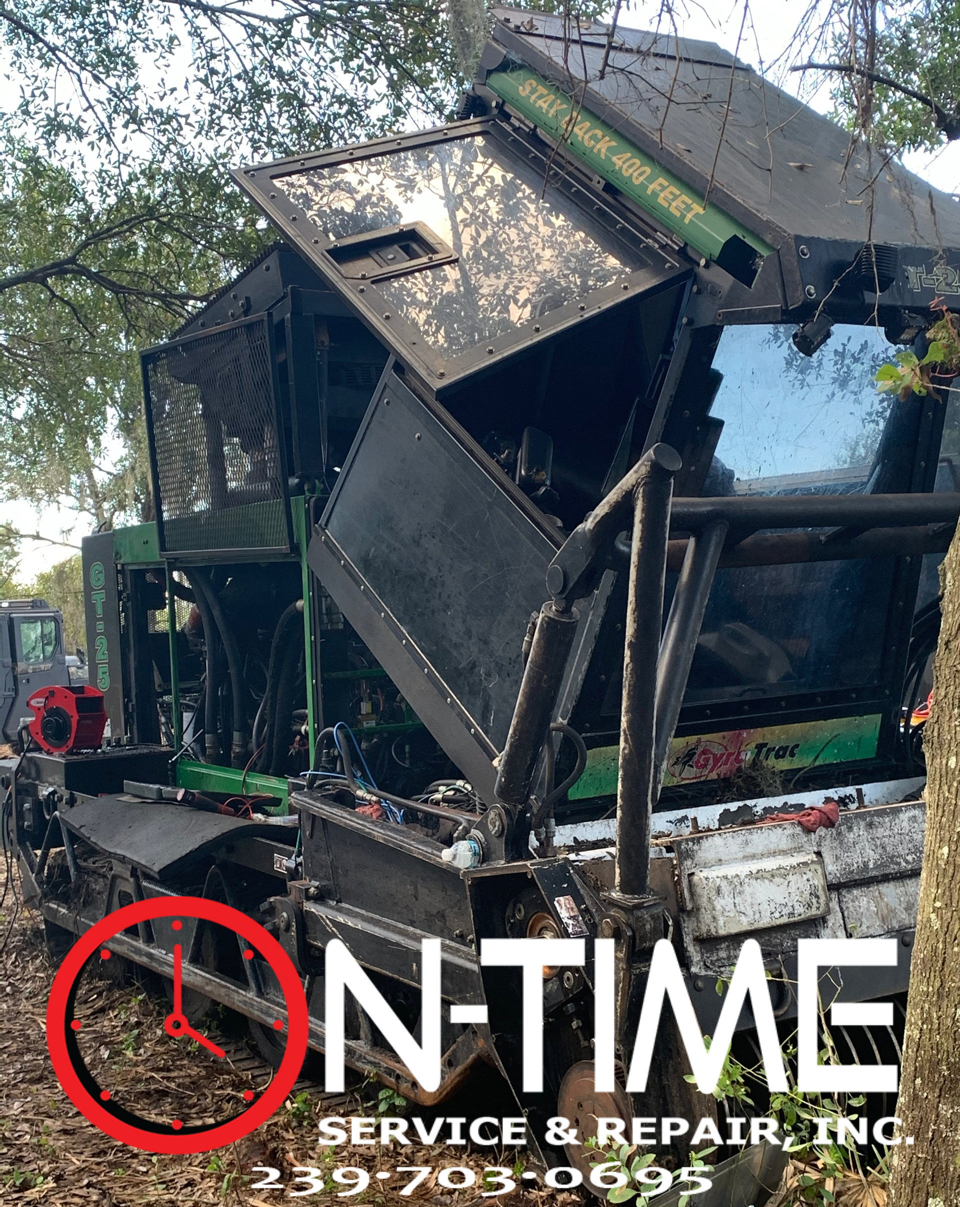A john deere tractor is sitting in the middle of a forest.