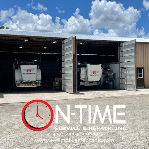 Two trucks are parked in a garage that says on time service & repair inc.