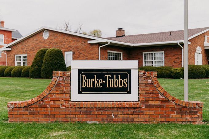 A funeral home with a black awning over the door