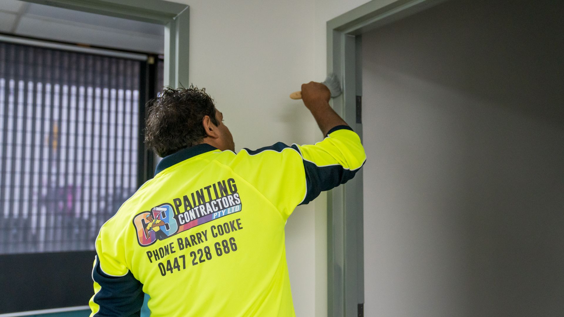 A man is painting a door with a brush.