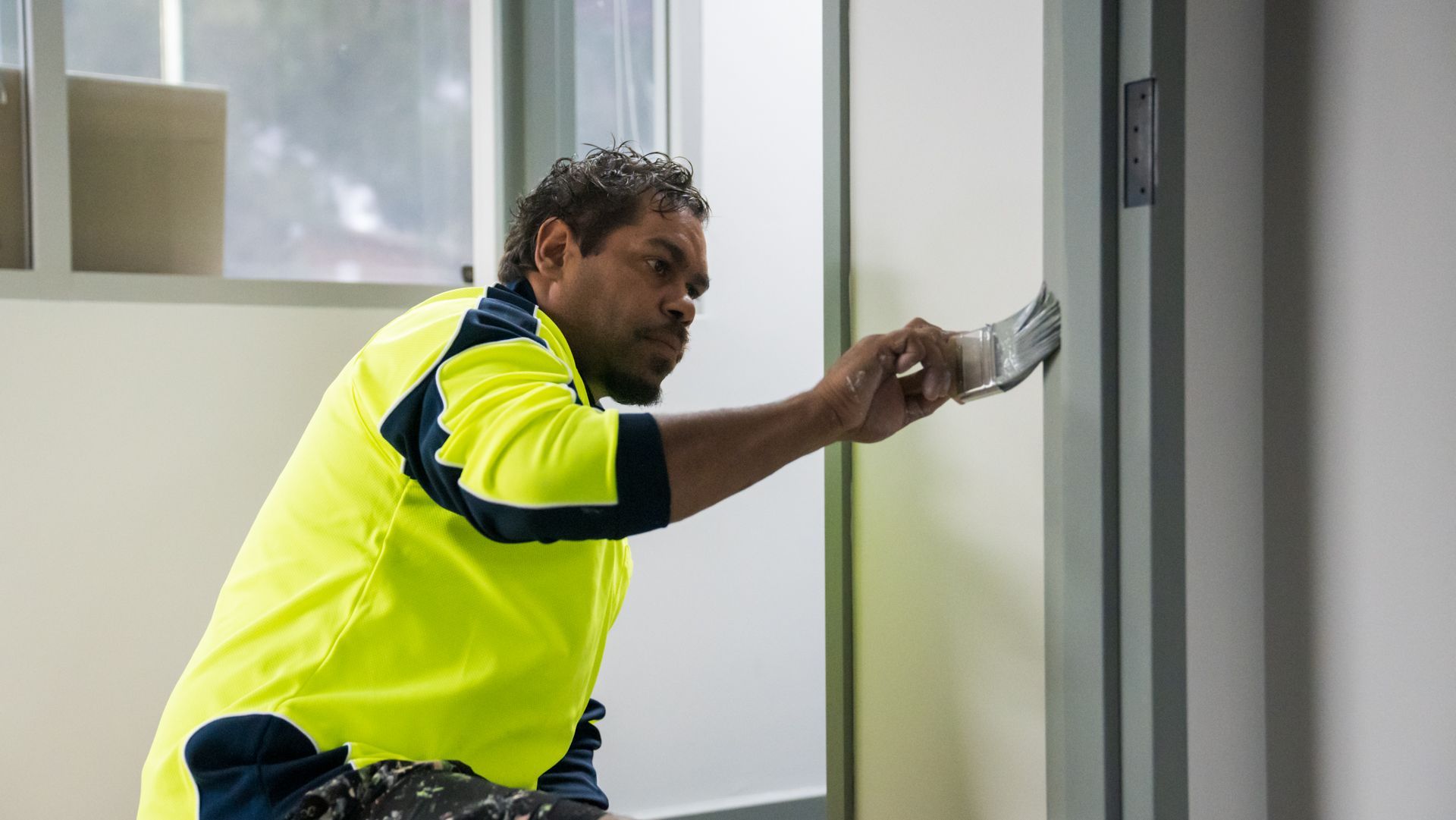 A man is painting a door with a brush.