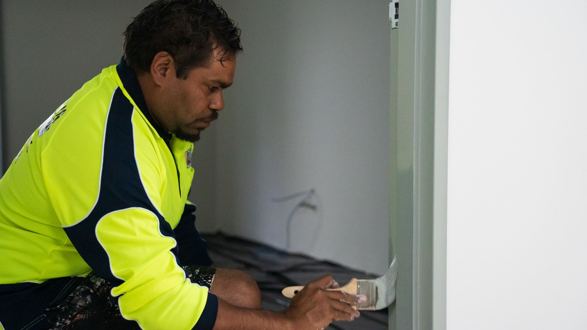 A man is painting a door with a brush.