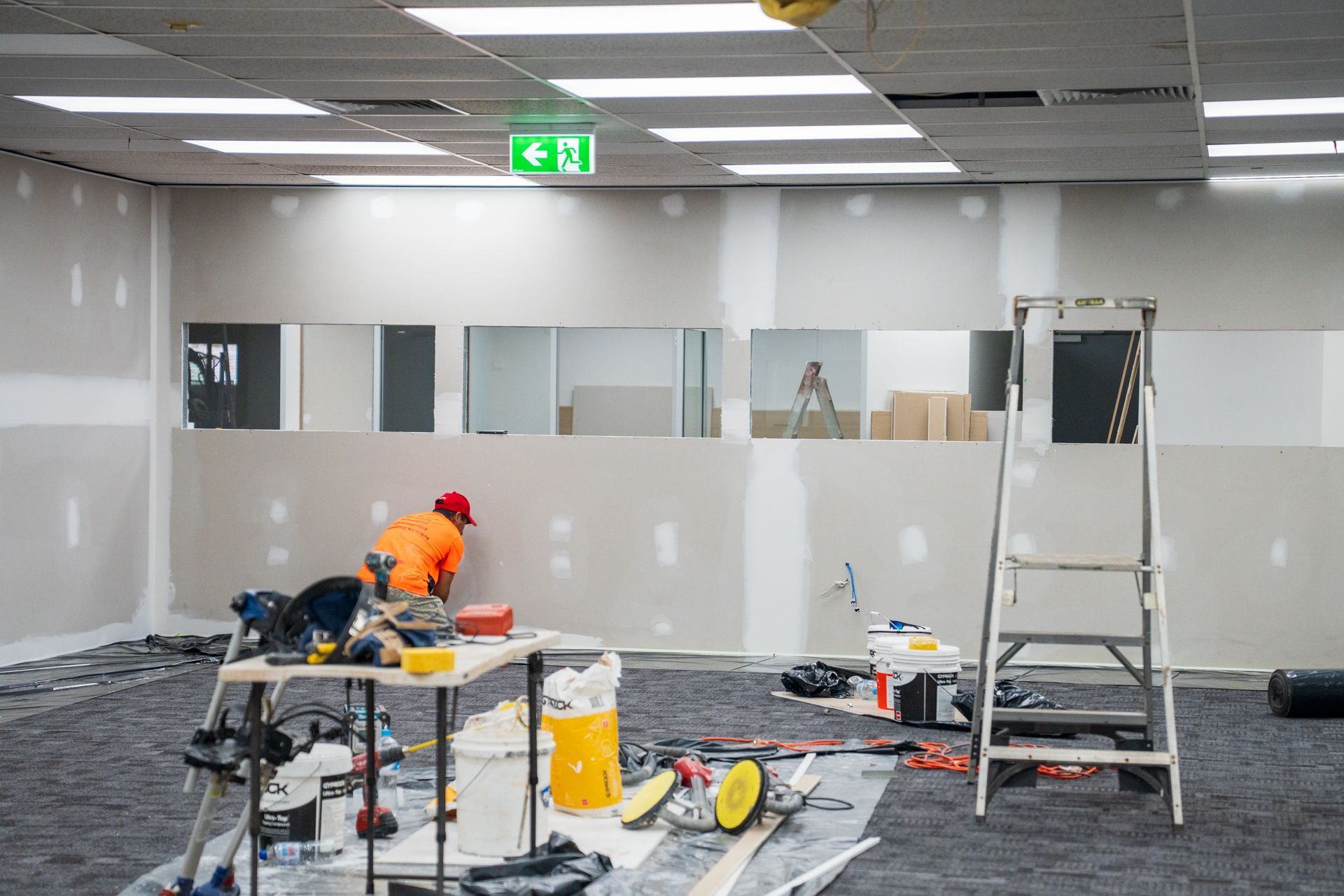 A man is working on a wall in a room.