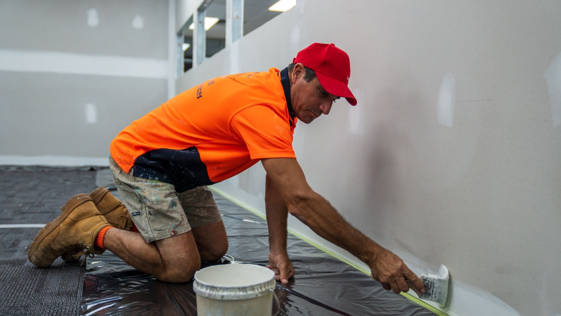 A man is measuring a wall with a tape measure.