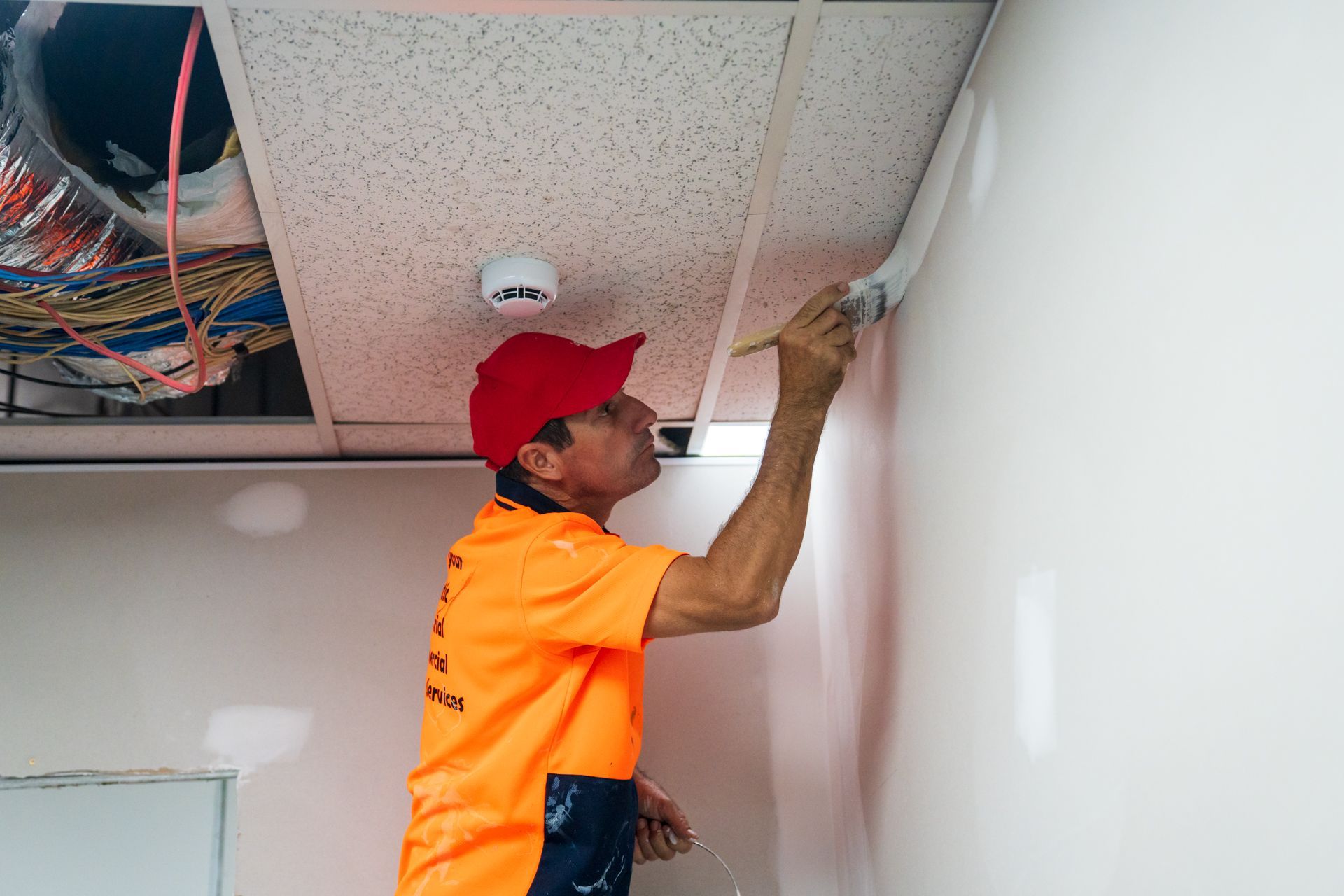A man is painting a wall with a brush.