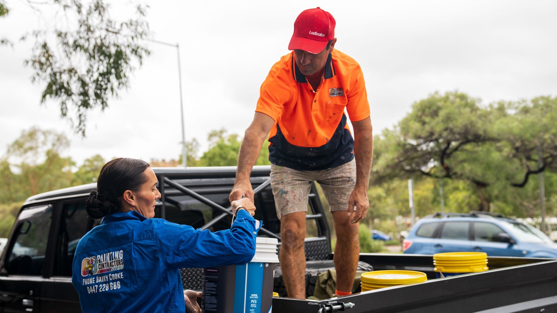 A man and a woman are shaking hands in the back of a truck.