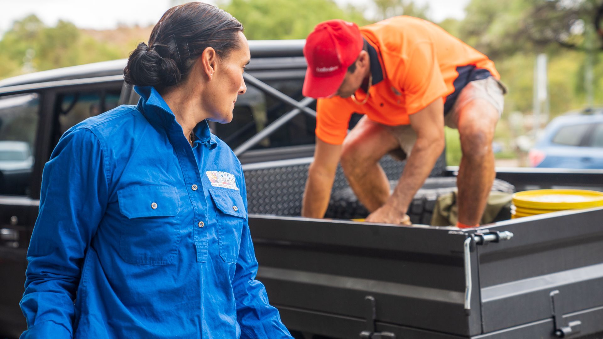 A man and a woman are standing next to a truck.