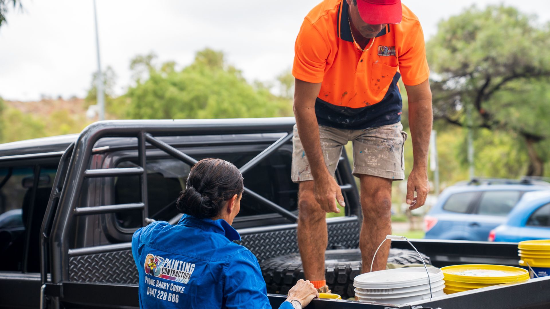 A man and a woman are loading plates into the back of a truck.