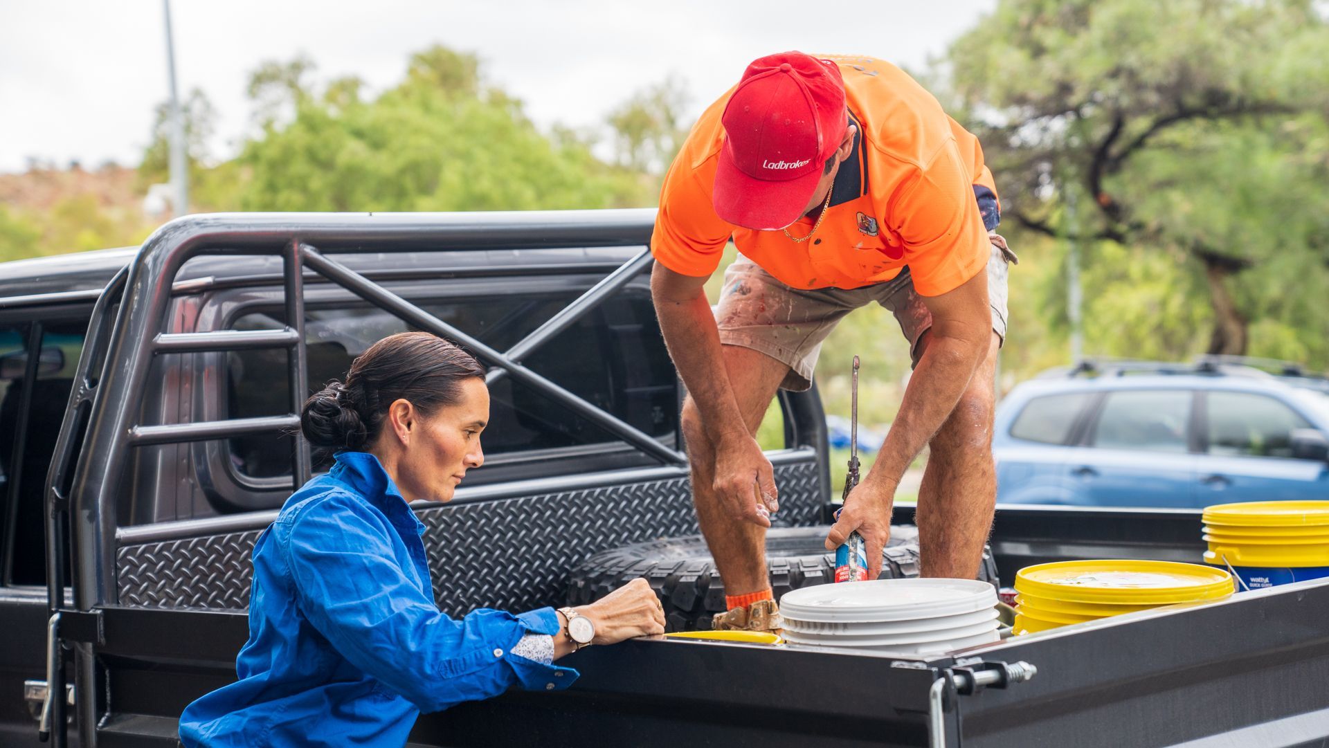 A man and a woman are working in the back of a truck.