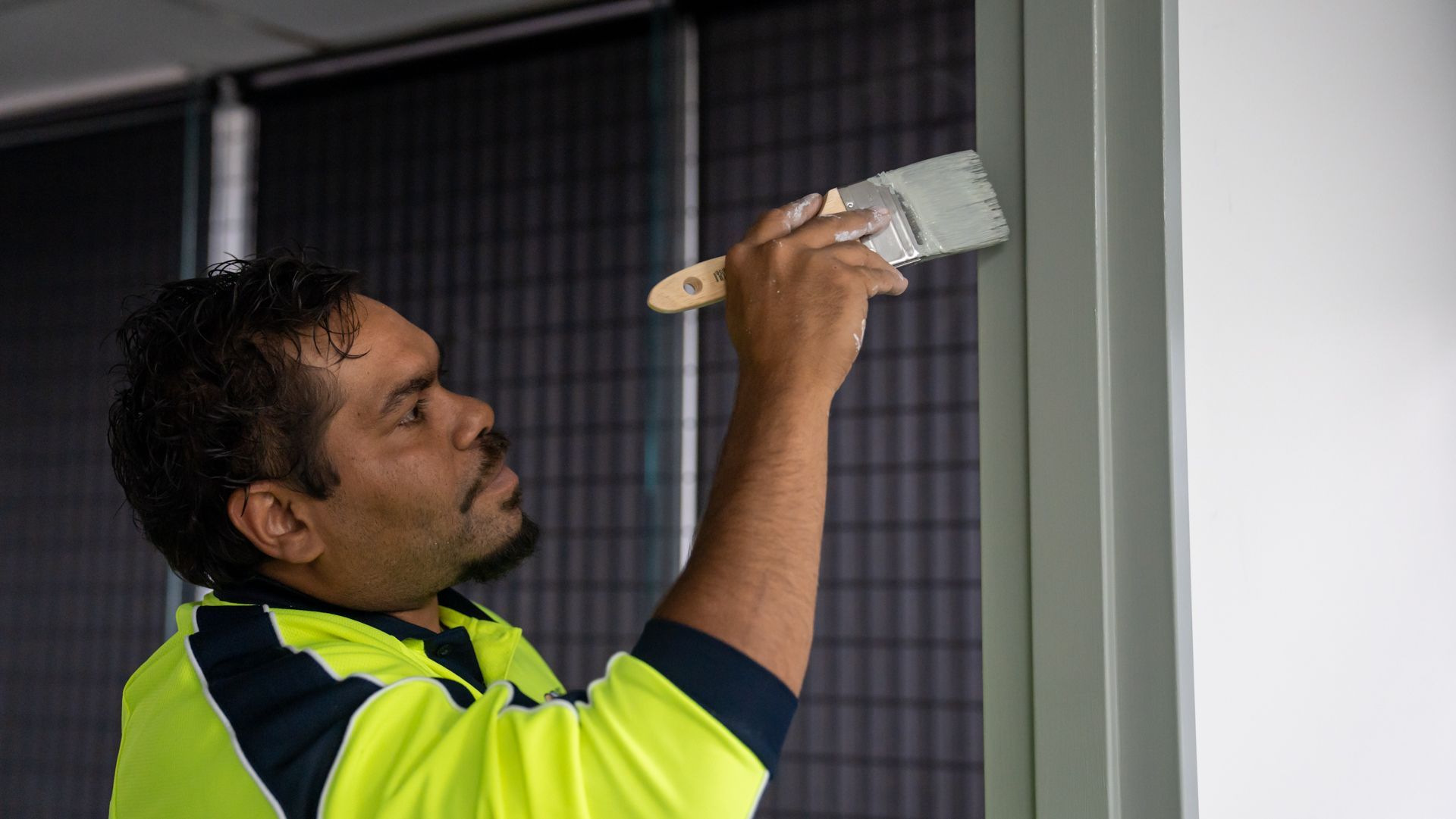 A man is painting a wall with a brush.