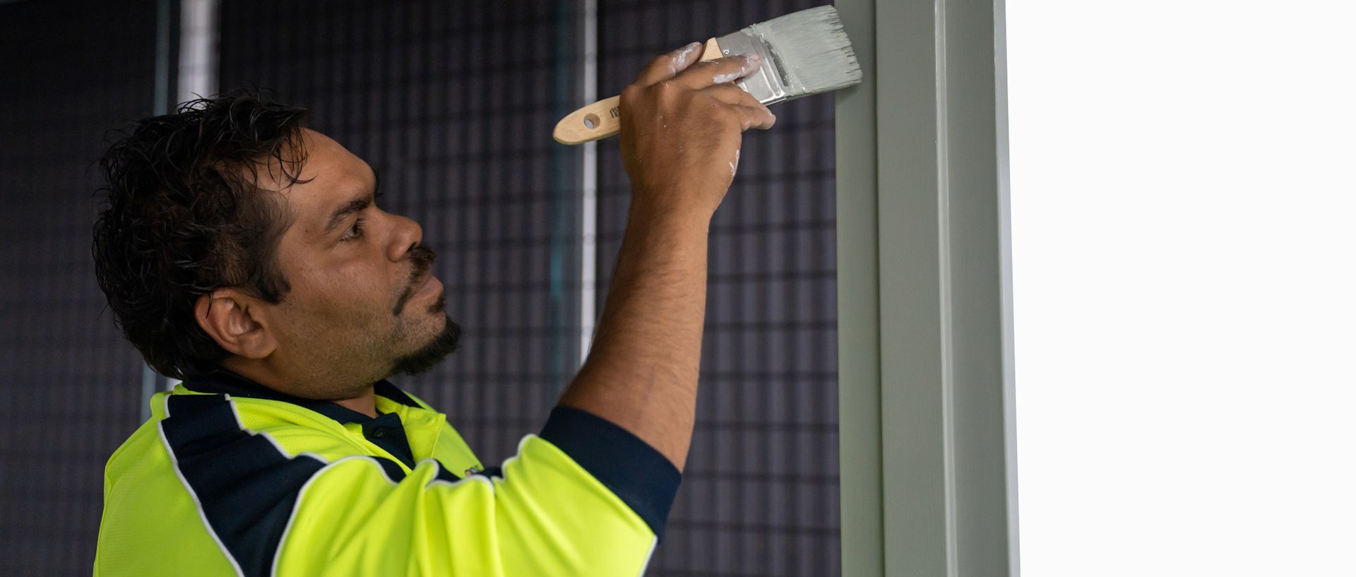 A man is painting a wall with a brush.