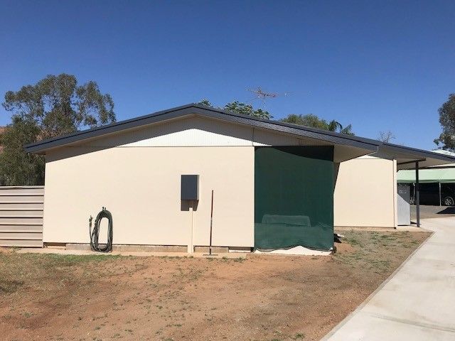 A house with a green door and a hose in front of it