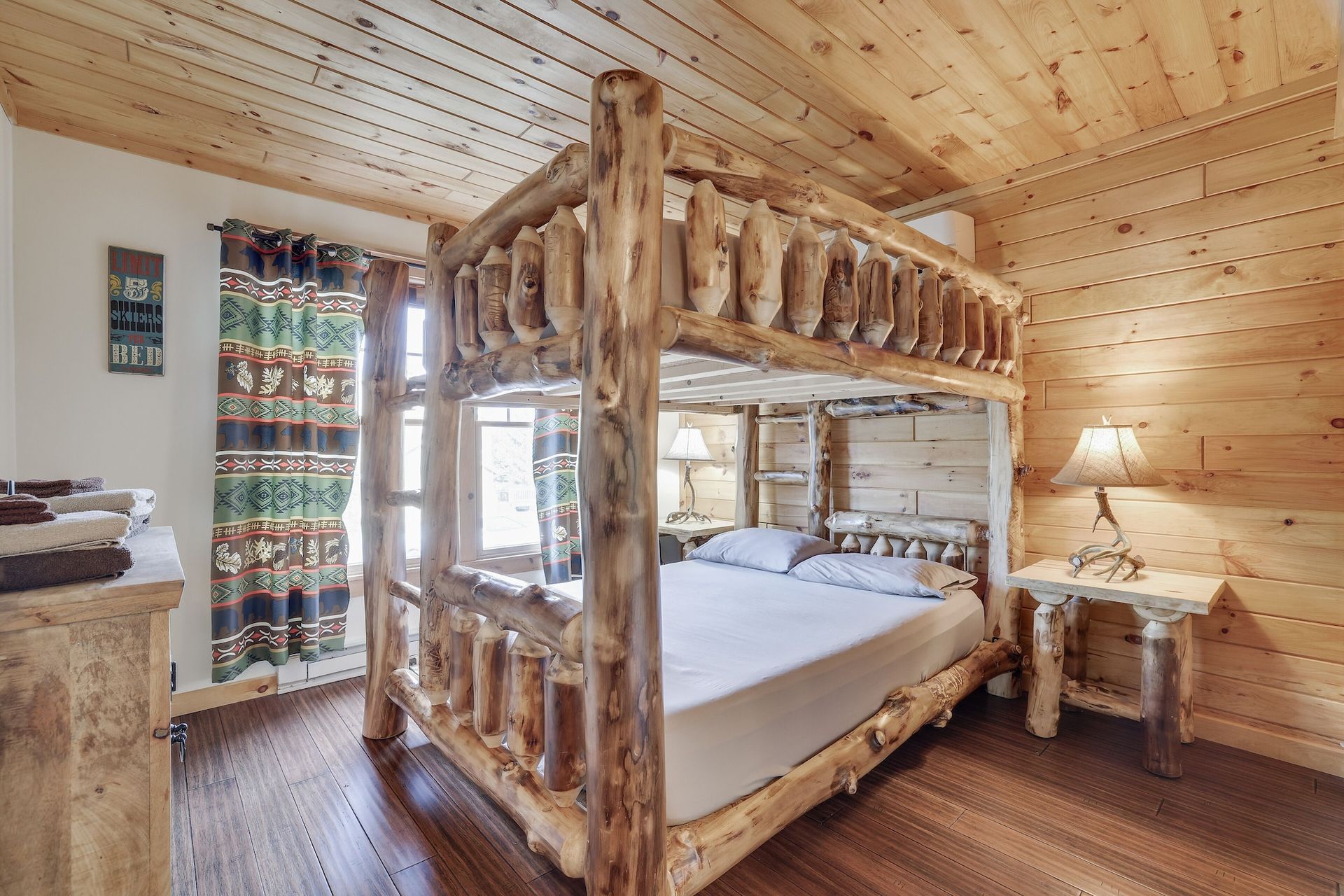 A bedroom with a bunk bed made of logs.