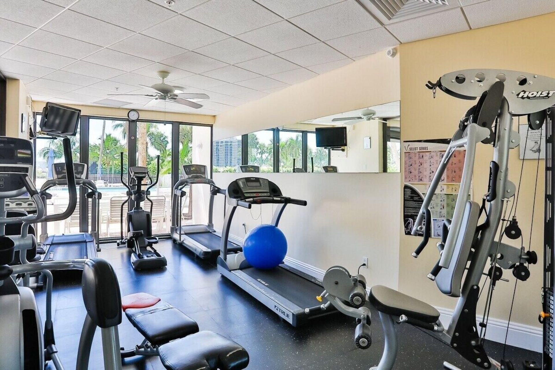A gym with treadmills and a blue ball