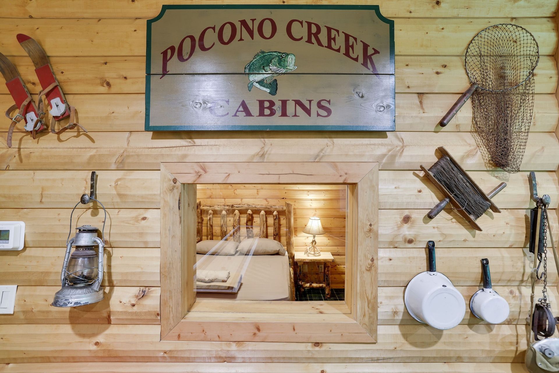 A wooden cabin with a sign on the wall that says pocono creek cabins.