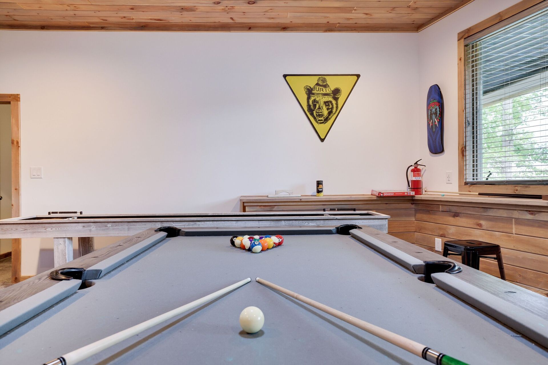 A pool table with a ball and cues in a room.