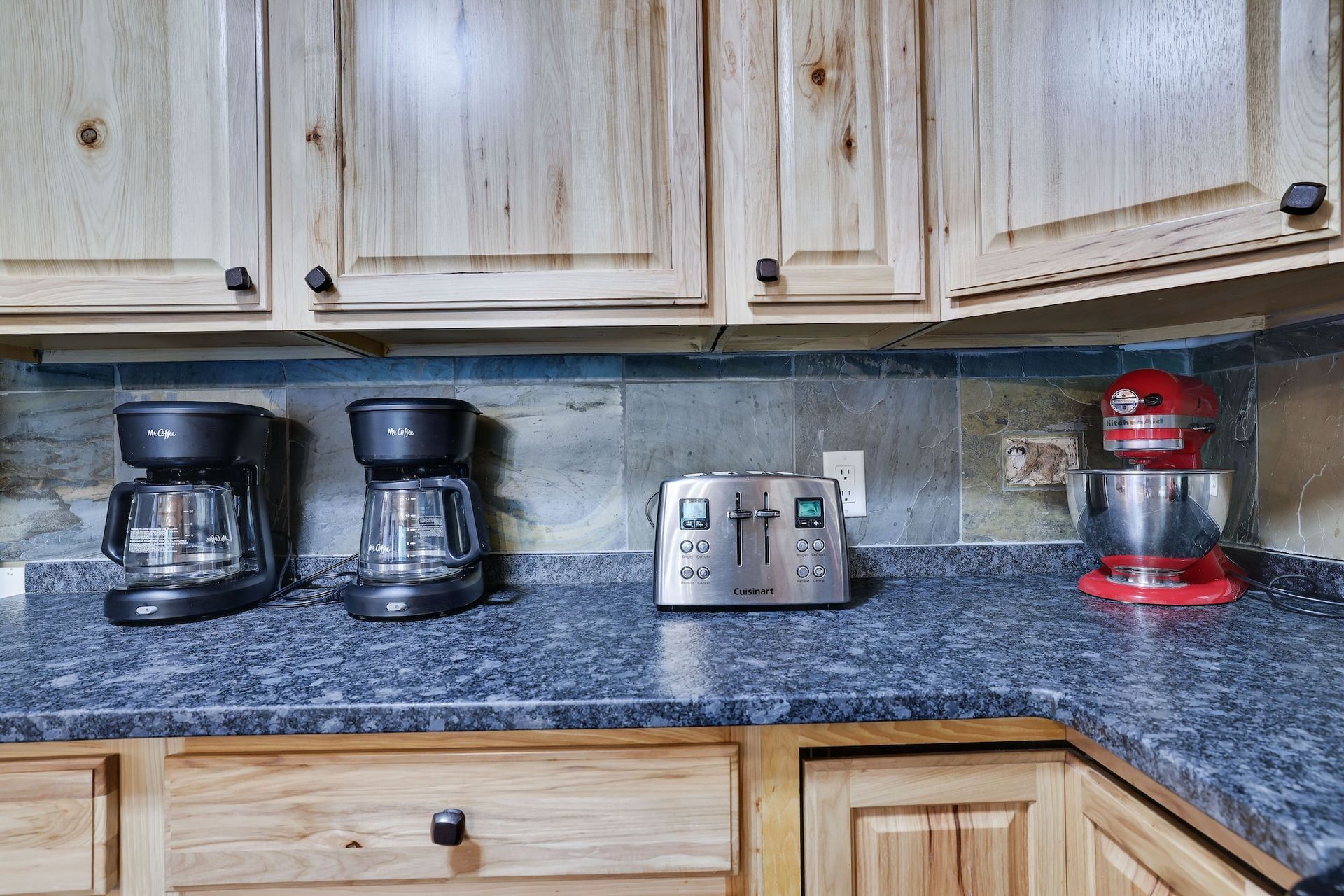 A kitchen counter with two coffee makers and a toaster oven.