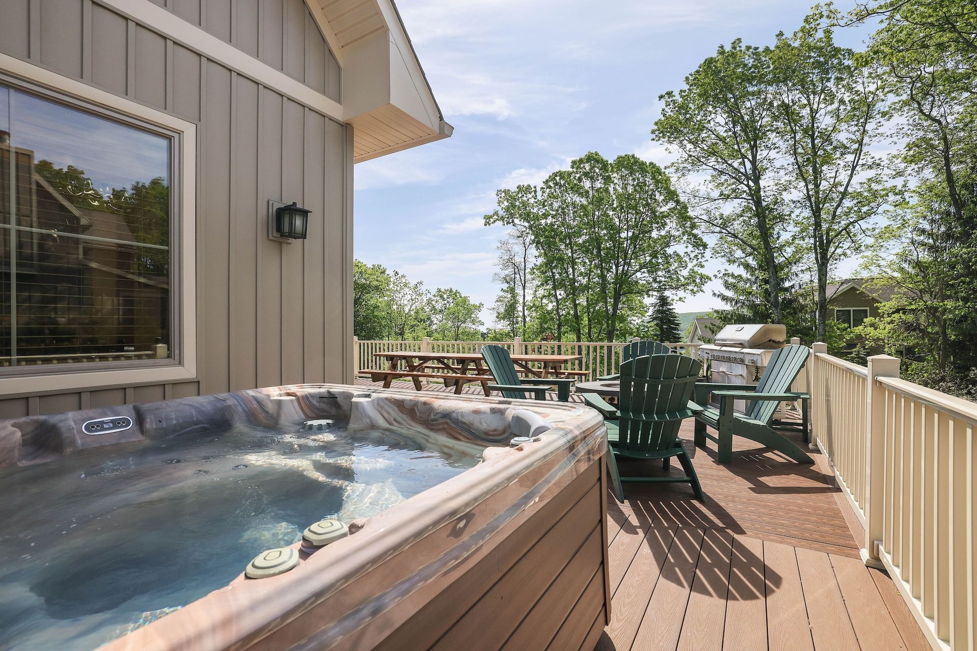 A hot tub on a deck next to a house