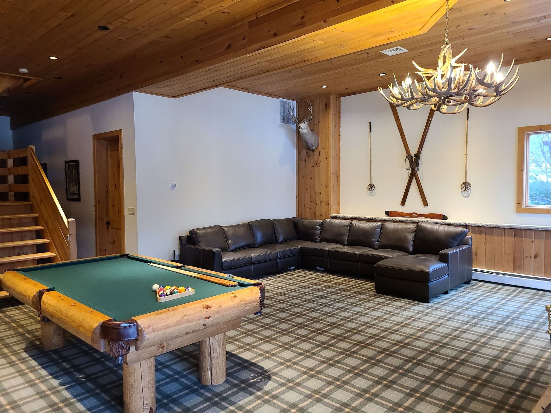 A living room with a pool table and a couch