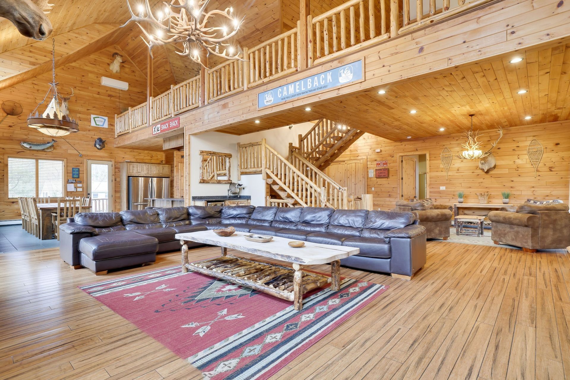 A living room filled with furniture and a staircase in a log cabin.