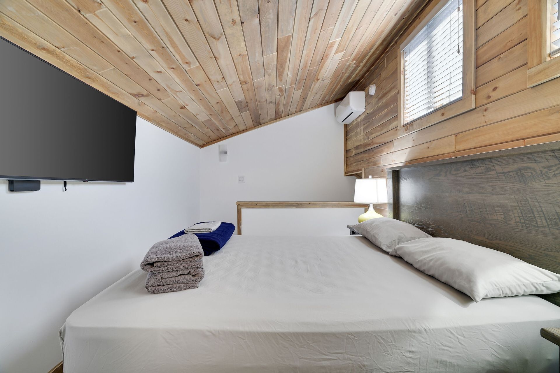 A bedroom with a king size bed and a flat screen tv