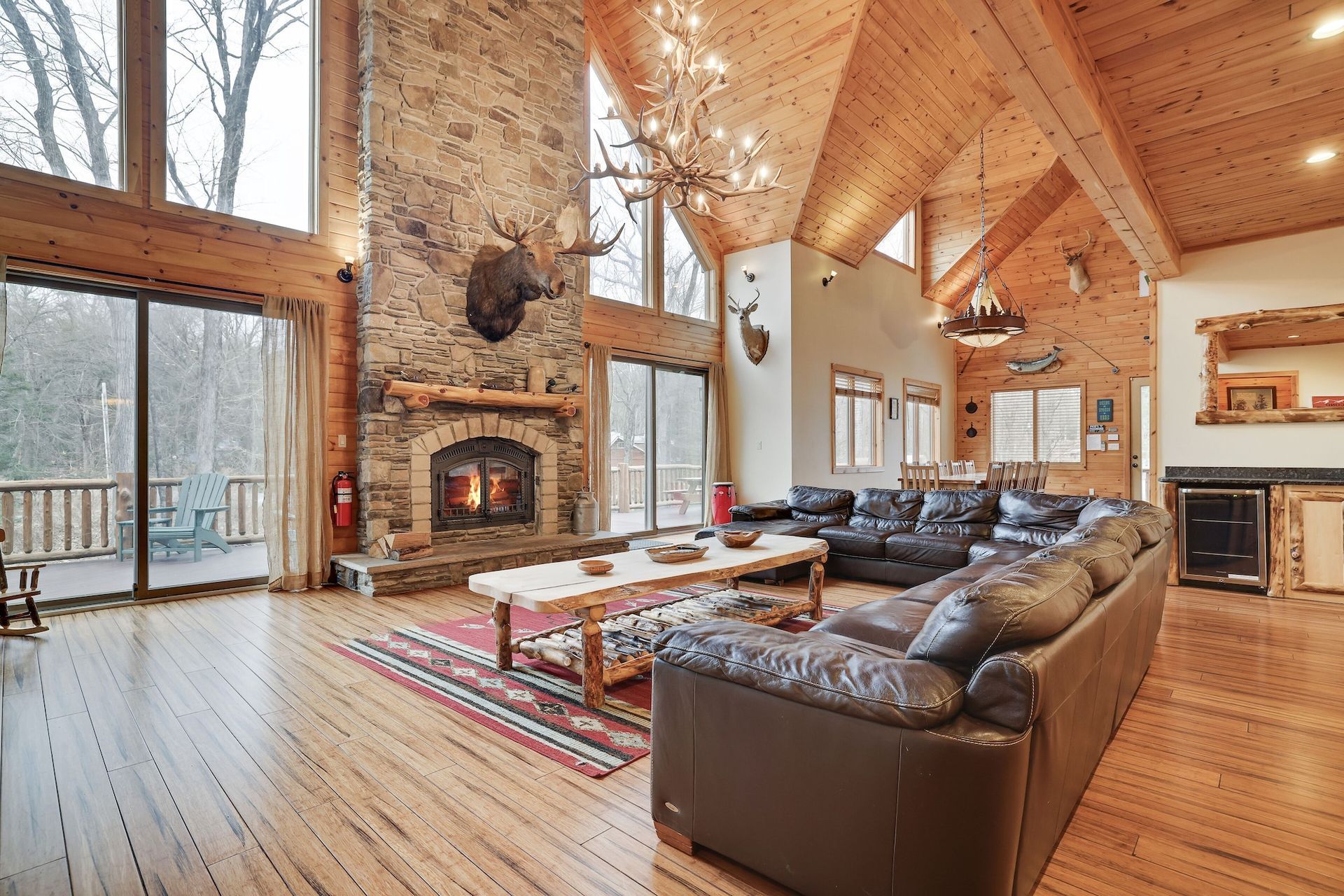 A large living room with a couch , fireplace , and lots of windows.