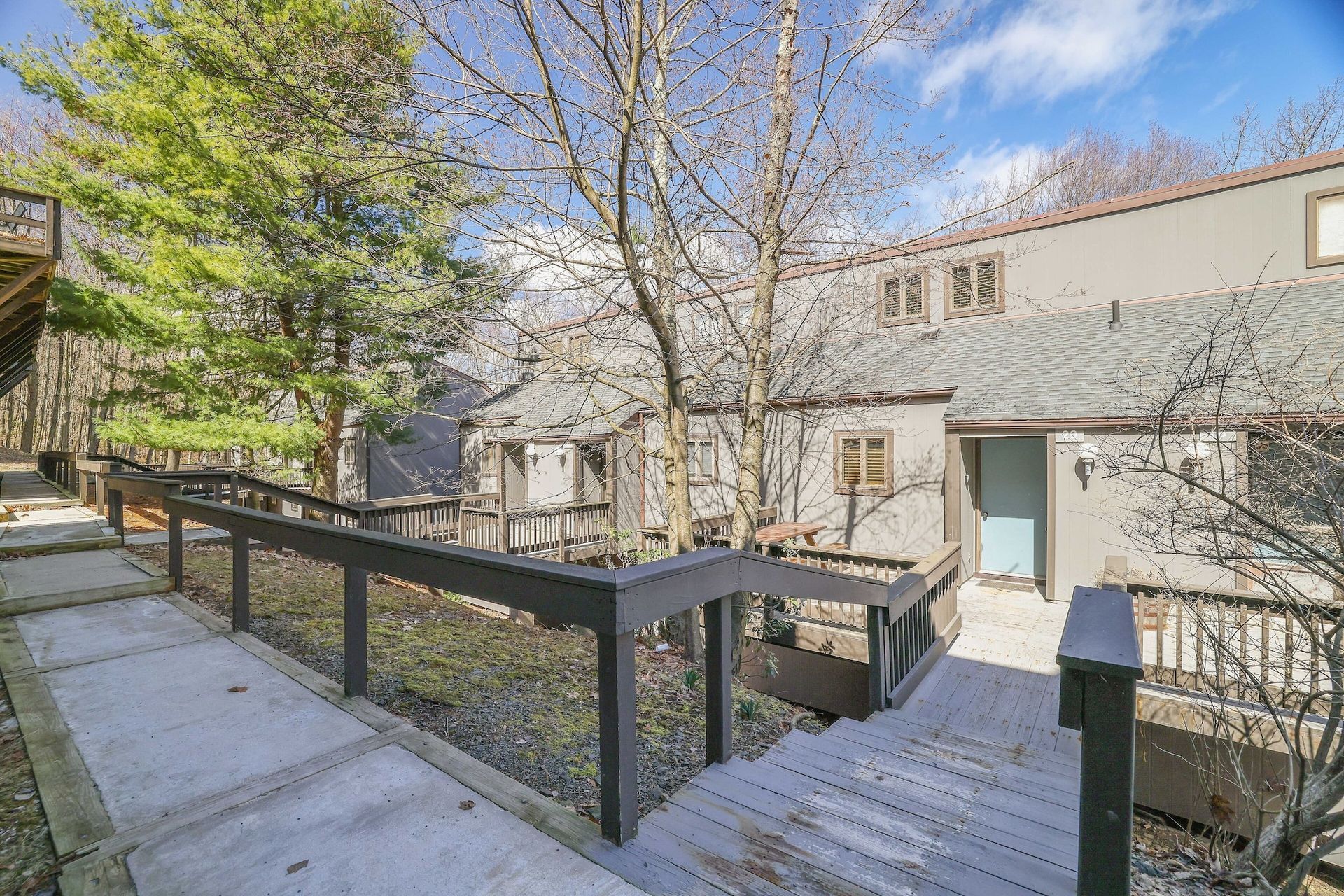 A house with a deck and stairs leading up to it.