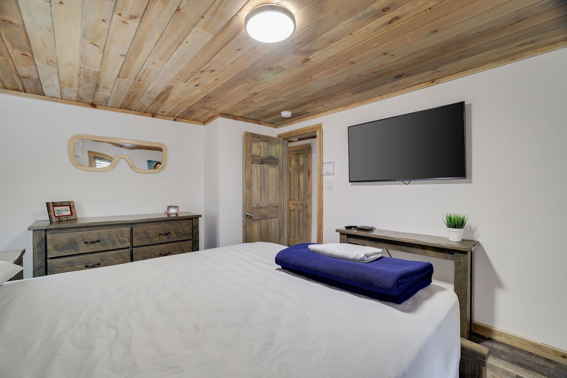 A bedroom with a bed , dresser , and television.
