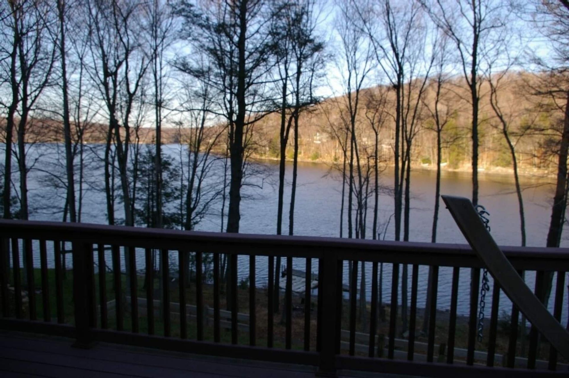 A view of a lake from a deck with trees in the background