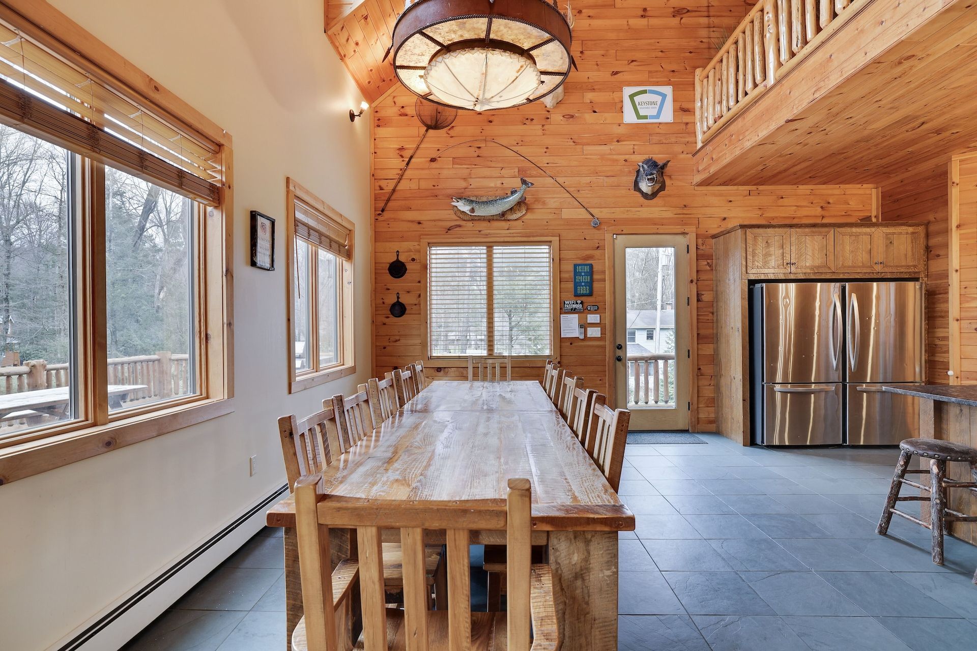 There is a long wooden table and chairs in the middle of the room.