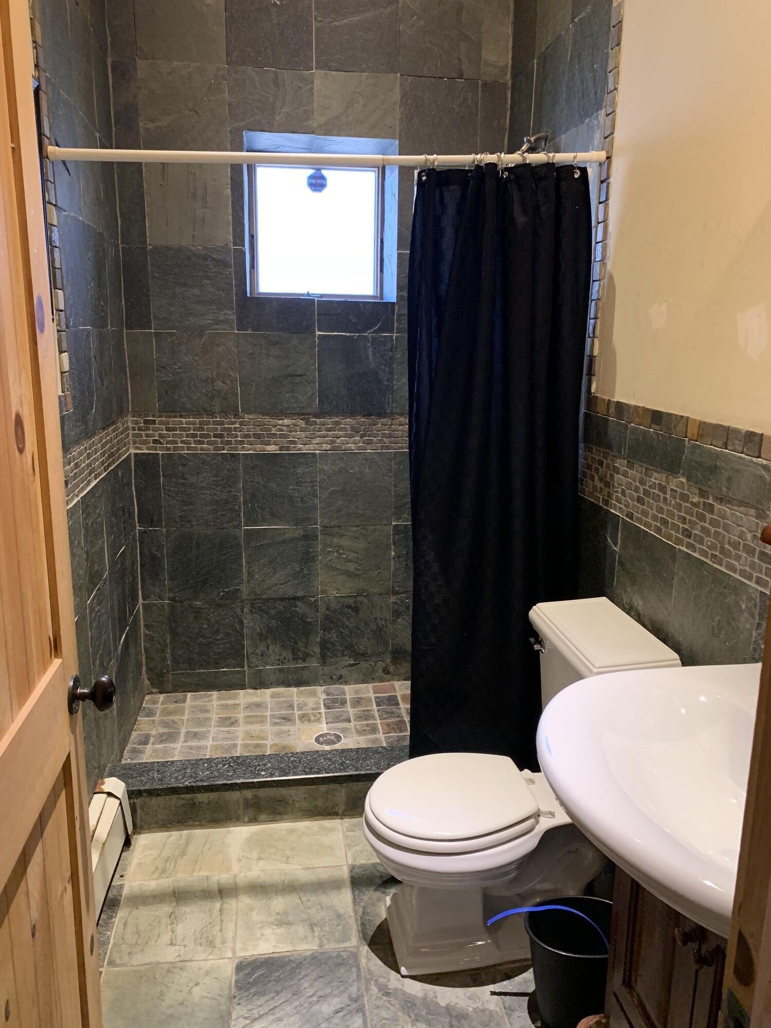 A bathroom with a toilet , sink , and shower.