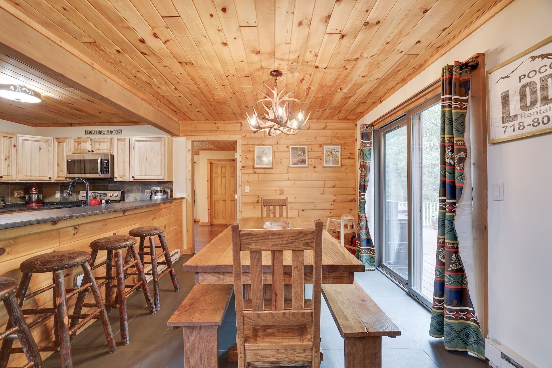 A dining room in a log cabin with a long wooden table and chairs.