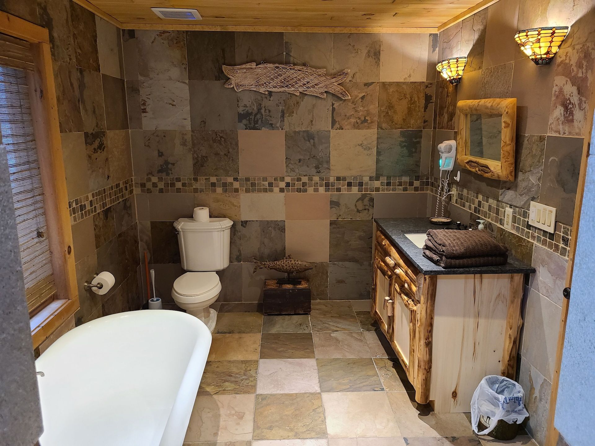 A bathroom with a tub , toilet , sink and mirror.