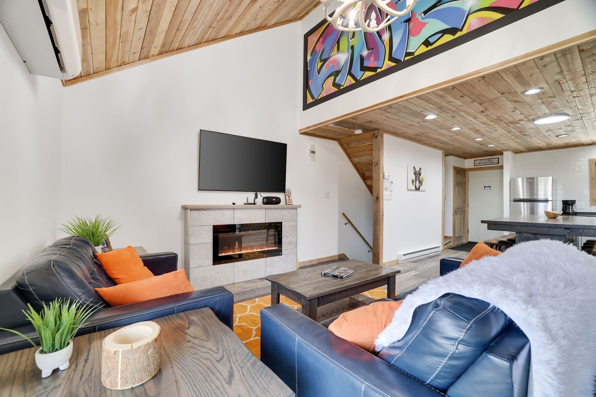 A living room with a couch , table , television and fireplace.